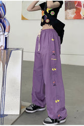 Lila Hose mit weitem Bein und seitlichem Cartoon-Print